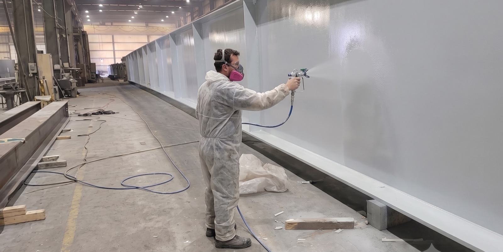 Shop application of industrial protective coatings to structural steel